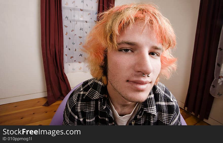 Closeup of a Young man with Bright Hair in a Bare Room