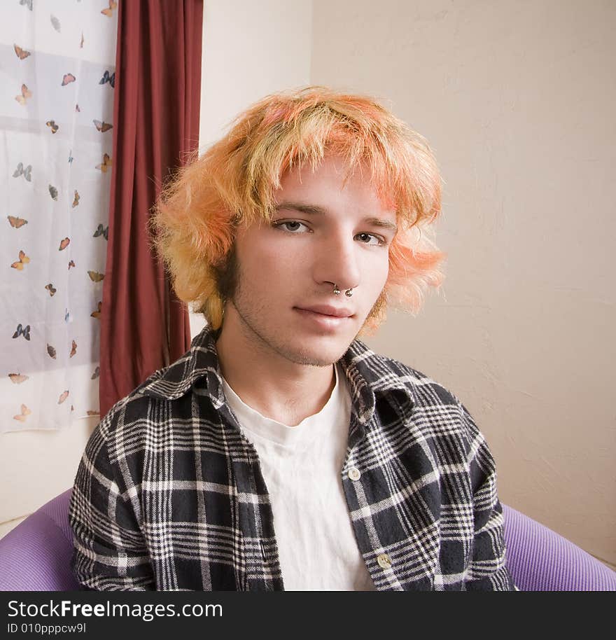 Closeup of a Young man with Bright Hair in a Bare Room