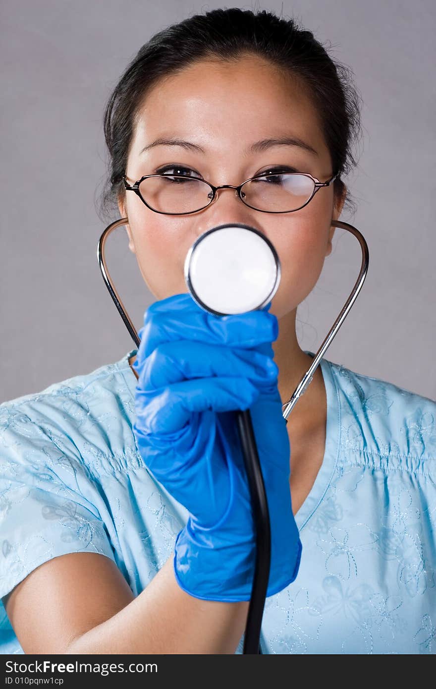 Health care young nurse pointing a stethoscope.