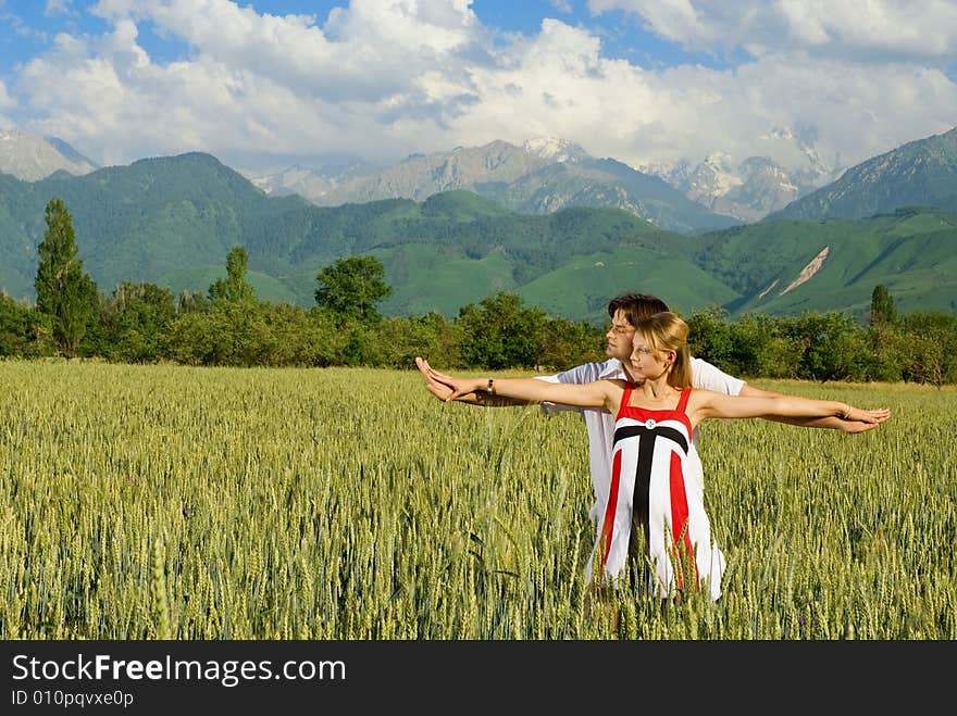 Young married couple in a wheat field, woman is pregnant. Young married couple in a wheat field, woman is pregnant