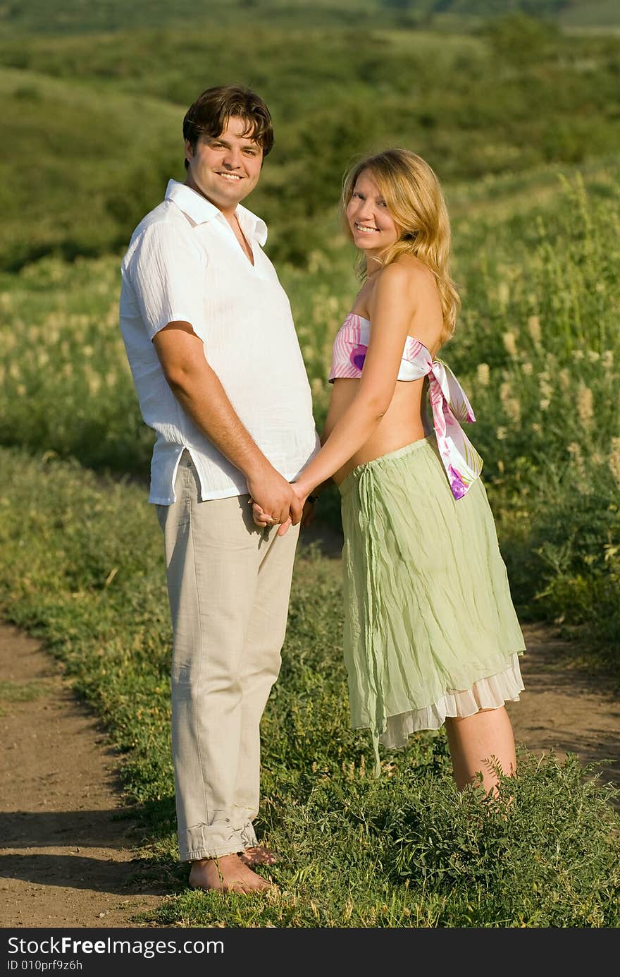 Young married couple on the walk, woman is pregnant