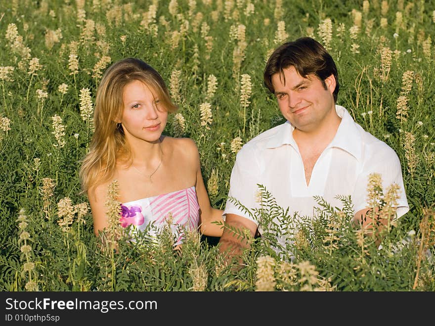 Happy couple sitting in the grass enjoying being together