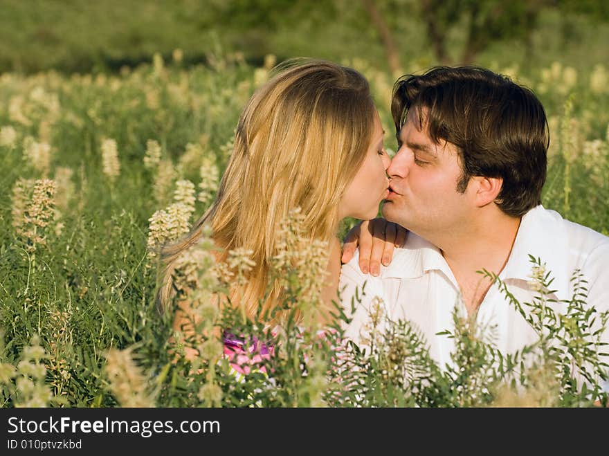 Happy couple sitting in the grass enjoying being together