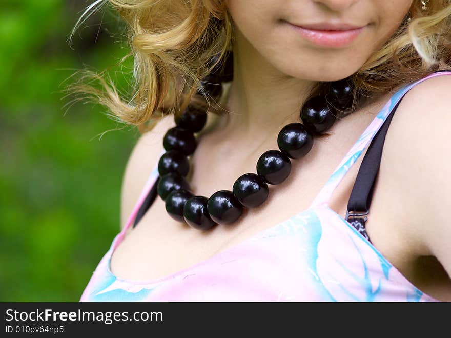 Beautiful girl with black necklace at summer