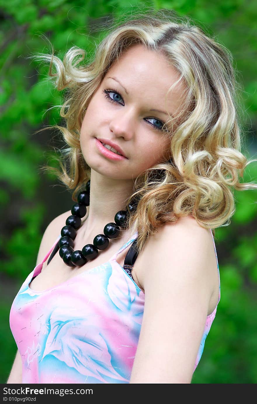 Beautiful girl with black necklace at summer