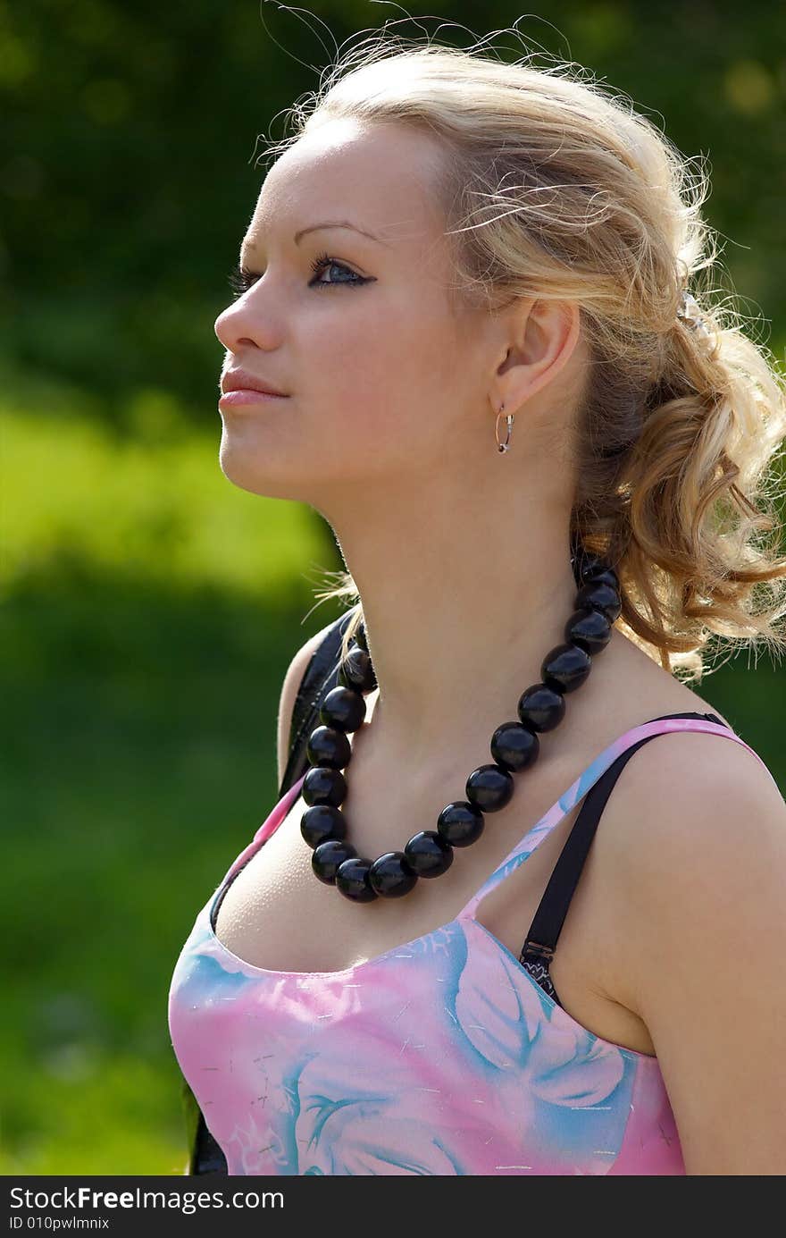 Beautiful girl with black necklace at summer