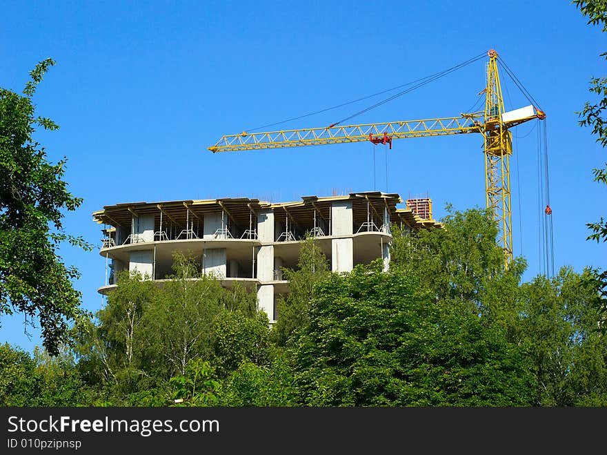 Machine for hoisting heavy materials on background a sky. Machine for hoisting heavy materials on background a sky