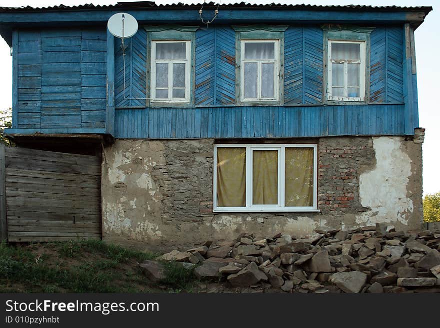 The old house with new windows and satellite антеной as a symbol of arrival of new time in a traditional way of life. The old house with new windows and satellite антеной as a symbol of arrival of new time in a traditional way of life