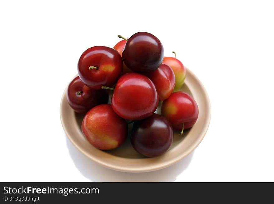 Plums on plate isolated on white background