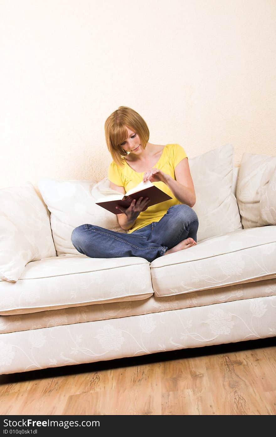 A young beautiful woman is reading on a lounge