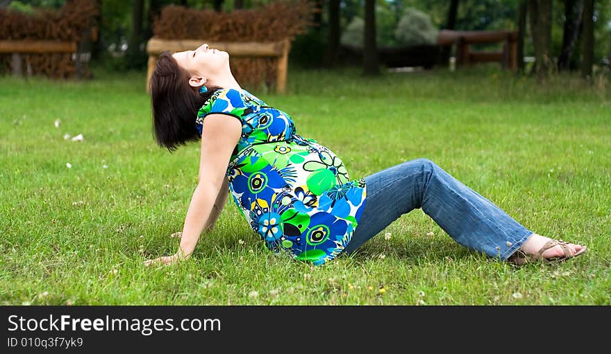 Pregnant woman relaxing on grass. Pregnant woman relaxing on grass