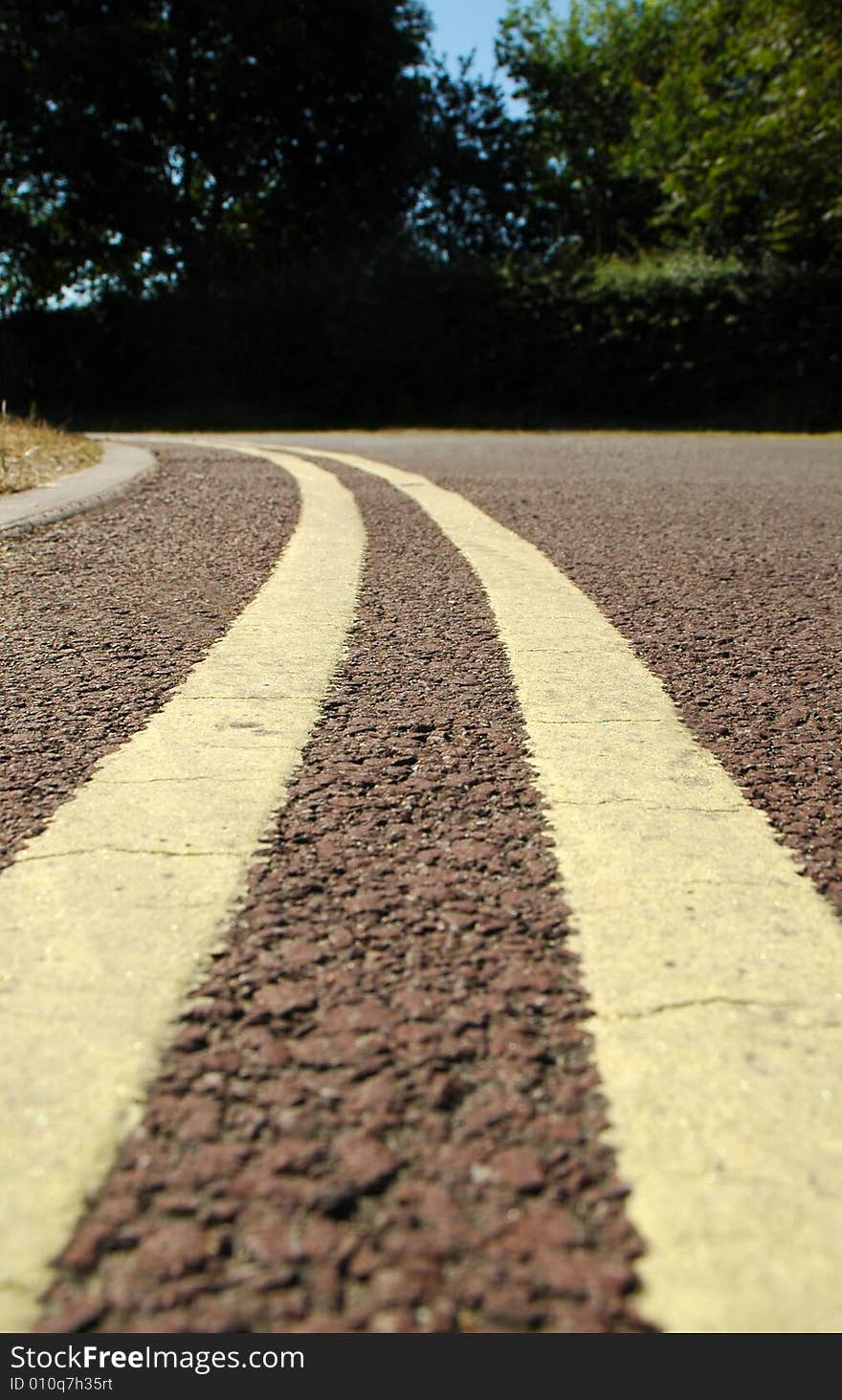 Close-up of double yellow parking lines bending around a corner. Close-up of double yellow parking lines bending around a corner