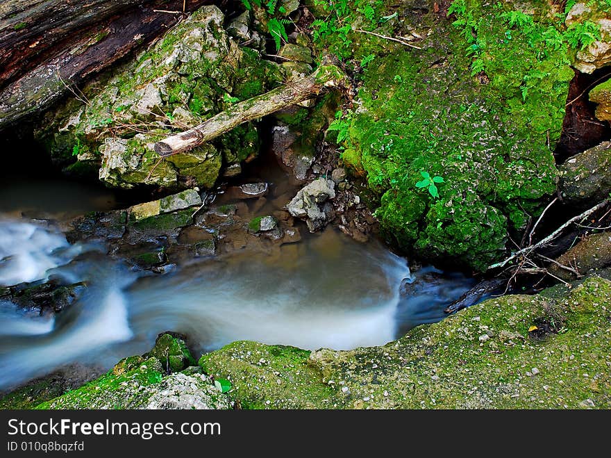 This is an area of a dam on a small creek. The water has broke through on one side.The view is taken from the top of the dam looking down. This is an area of a dam on a small creek. The water has broke through on one side.The view is taken from the top of the dam looking down.