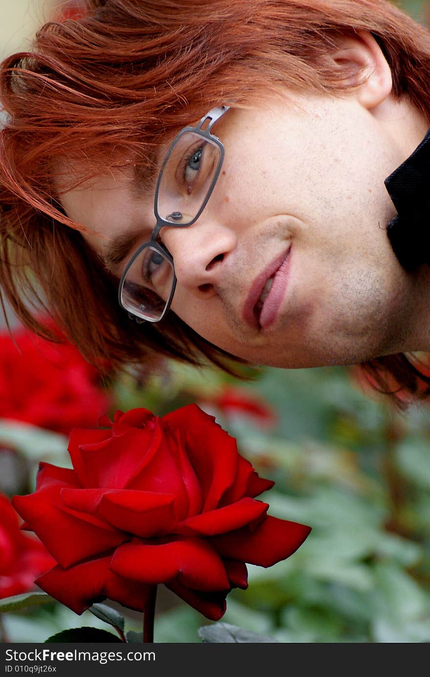 A young man with a beautiful and huge red rose. A young man with a beautiful and huge red rose