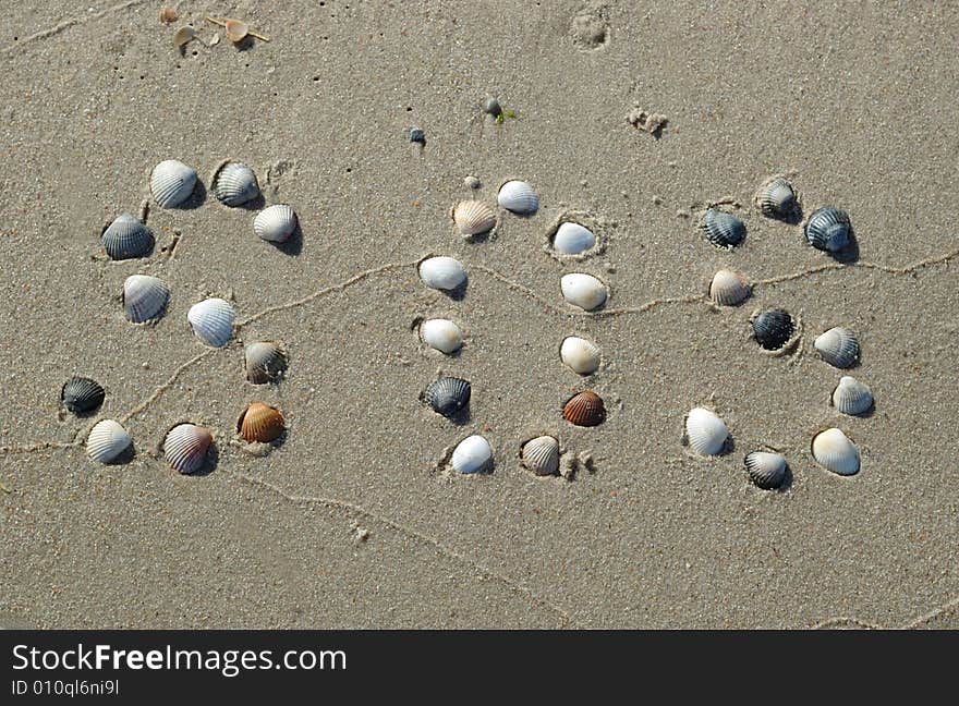 SOS signal on the sand made from shells