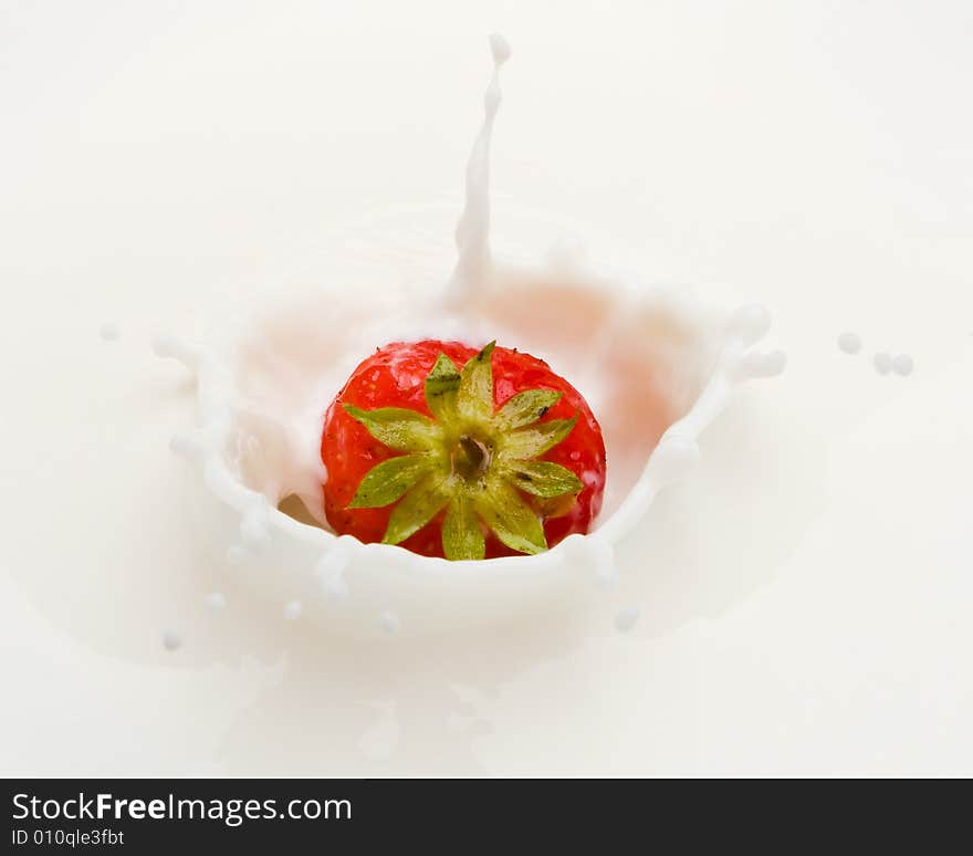 Delicious strawberry splashing into milk