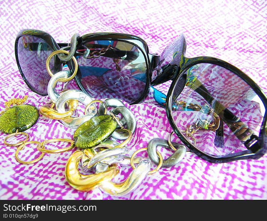 Sunglasses on a color background with a beads