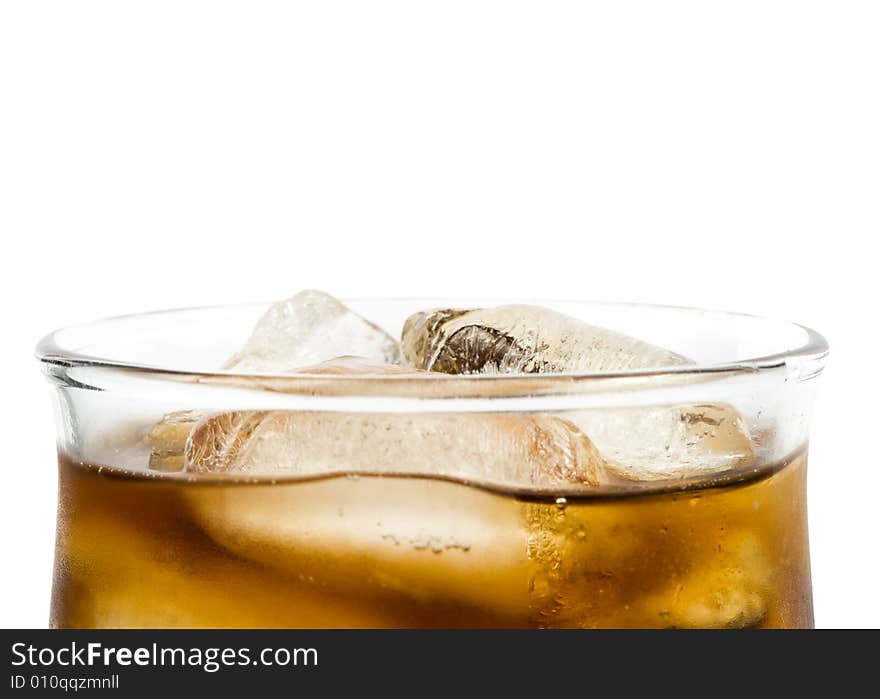 Cold fizzy cola with ice in a glass. Close up.