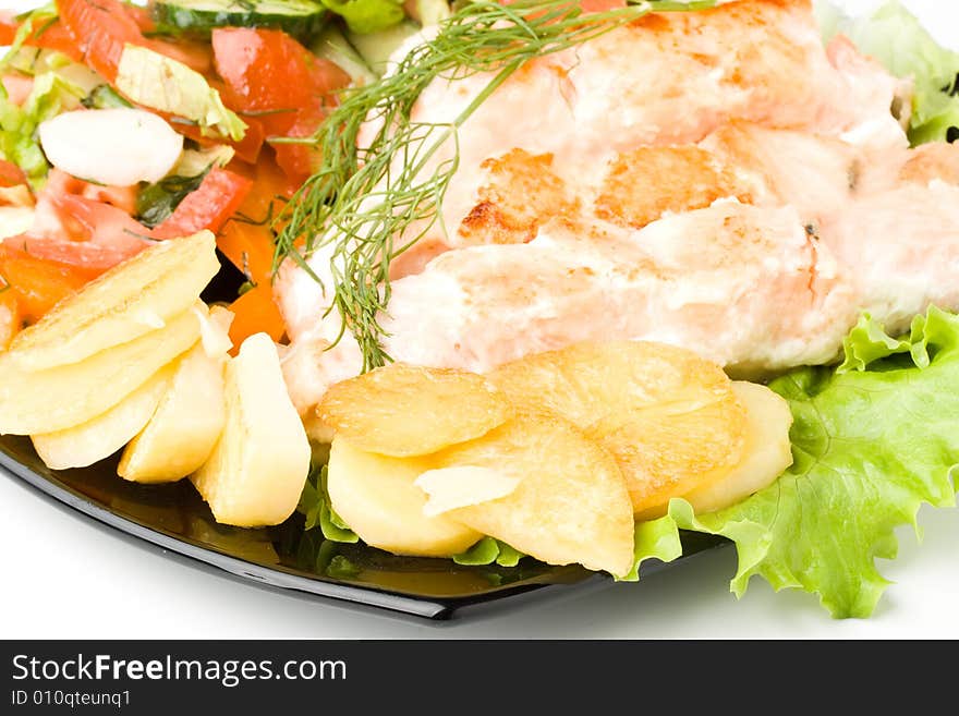 Stake from a salmon with vegetables on a plate. Closeup.