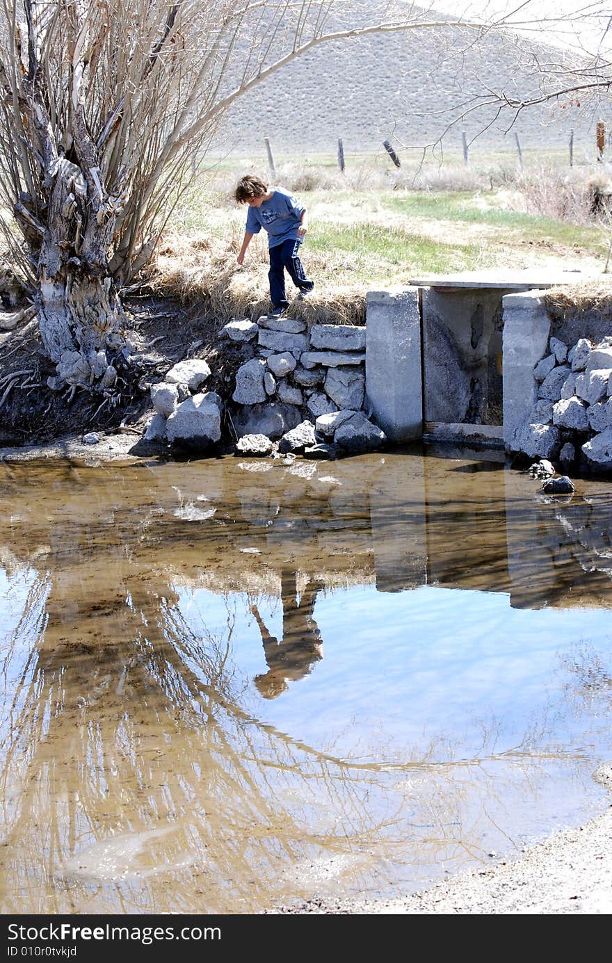 Boy exploring little lake, trying to catch a fish, Mammoth Mountain, CA.