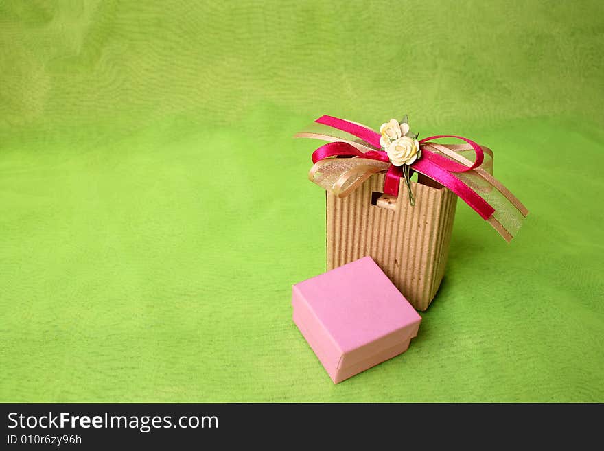 Pink gift box and brown gift bag with ribbons