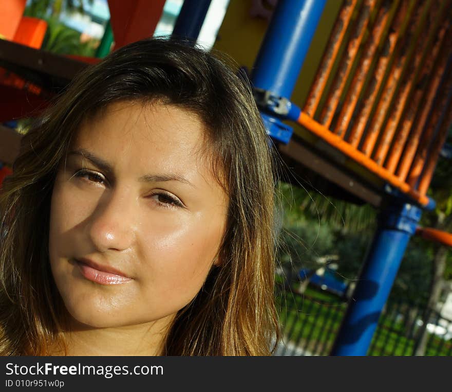 Headshot of a young female with a playground in the background. Headshot of a young female with a playground in the background.