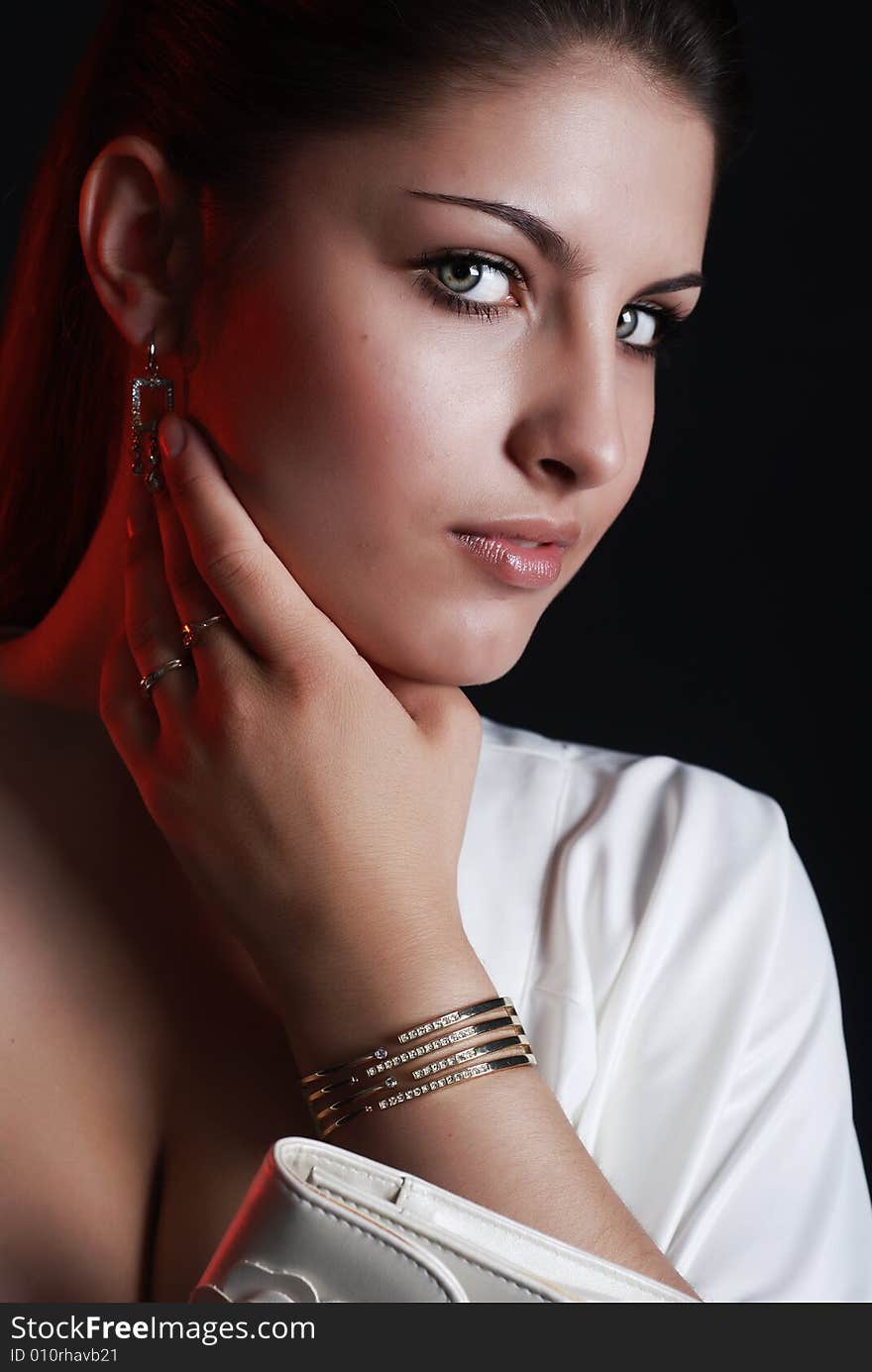 A young beautiful girl is dressed in white clothes at black background. A young beautiful girl is dressed in white clothes at black background