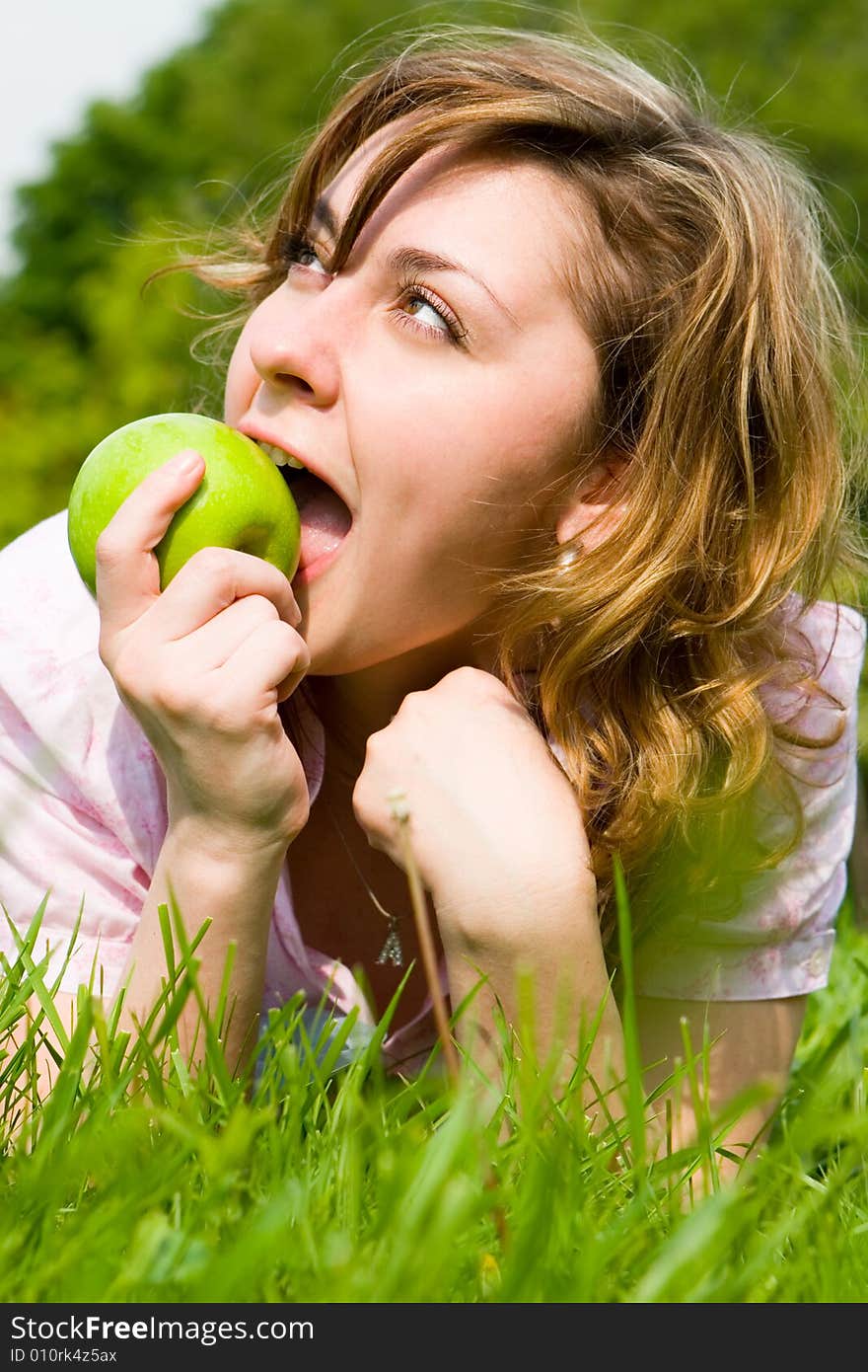 Pretty woman eating green apple