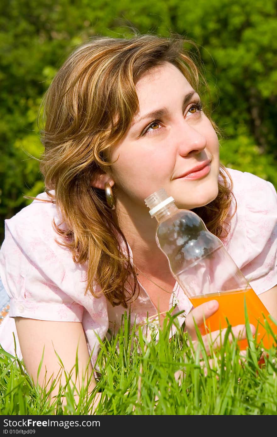 Woman drinking juice on the summer glade