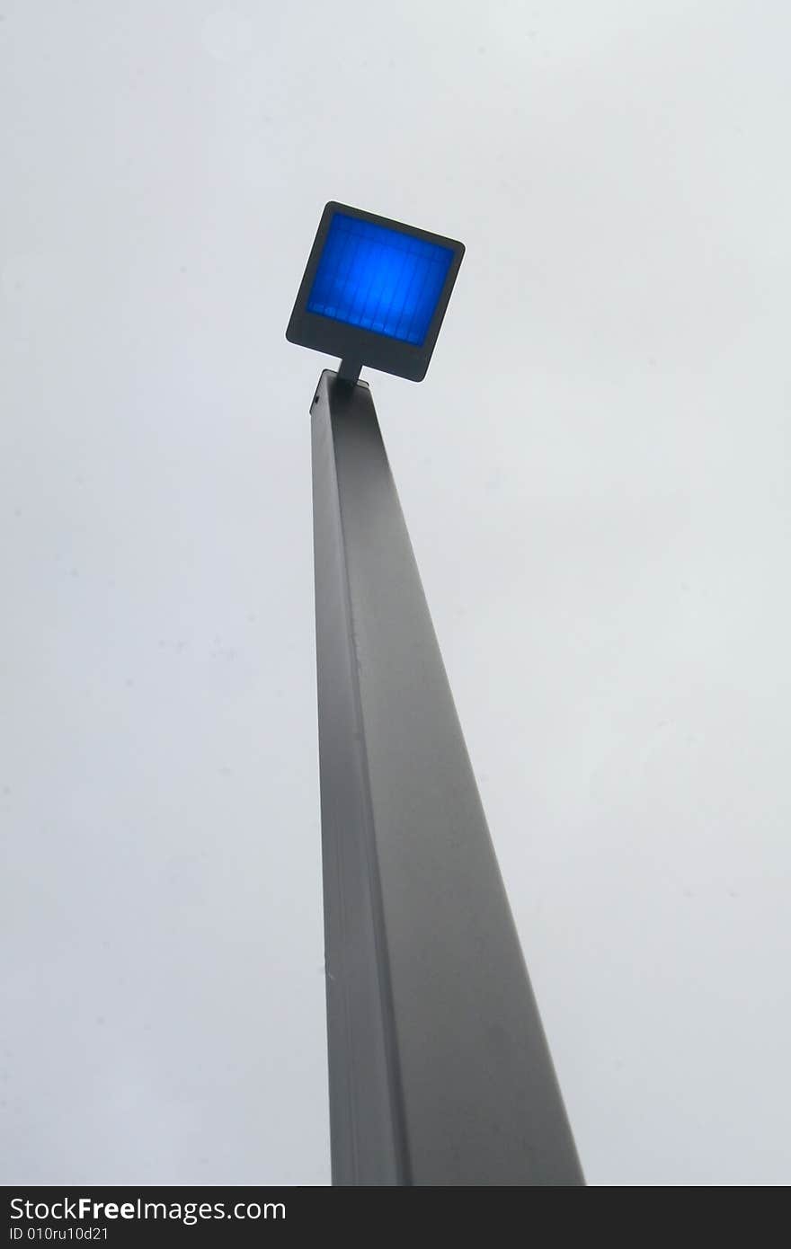 Bright blue light from light pole on grey day