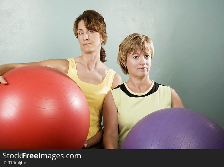 Two Physically Fit Women Posing With Exercise Balls