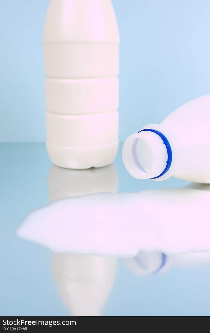 Spilt full cream milk isolated against a blue background. Spilt full cream milk isolated against a blue background