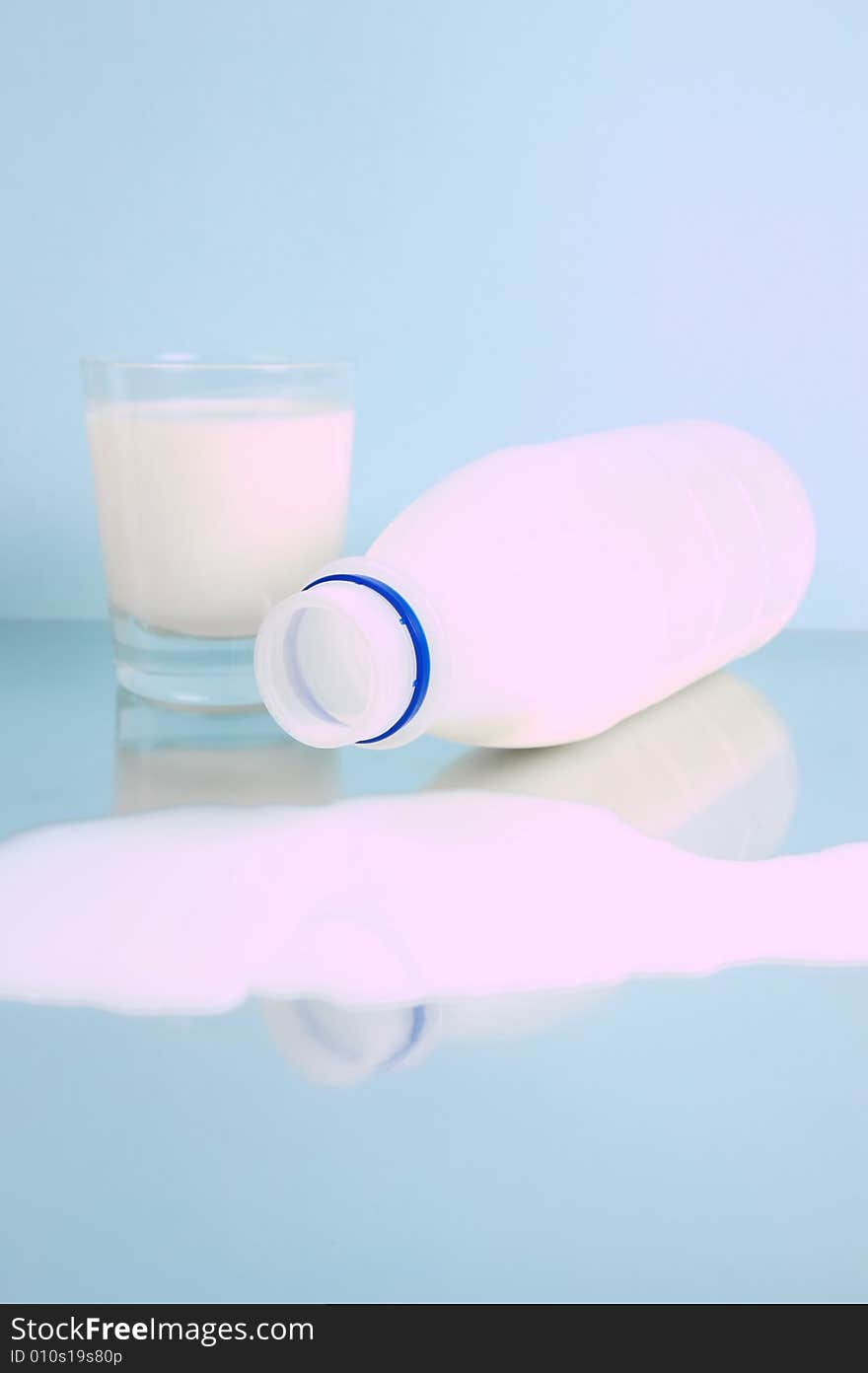 Spilt full cream milk isolated against a blue background. Spilt full cream milk isolated against a blue background