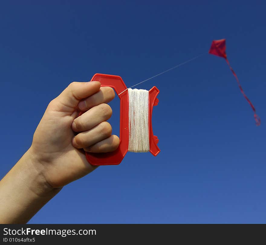 Girl flying a kite in a park with blue sky