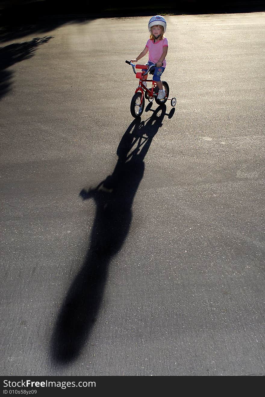 Little girl riding a bike wearing a helmet