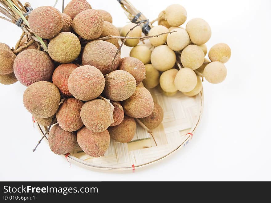 Lychee and longan fruits on woven bamboo tray. Lychee and longan fruits on woven bamboo tray