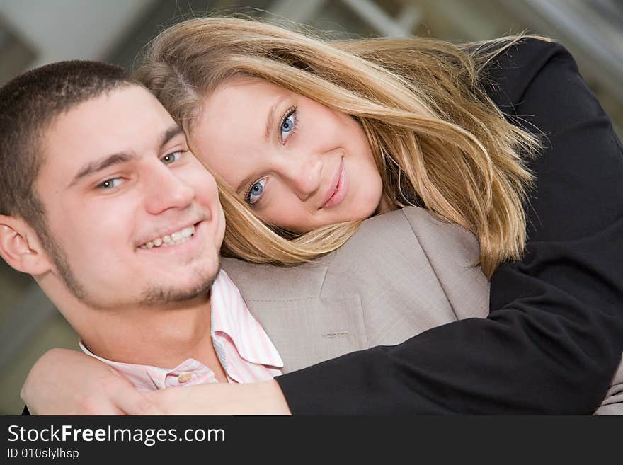 A beautiful blue-eyed blonde hugging a smiling man. A beautiful blue-eyed blonde hugging a smiling man