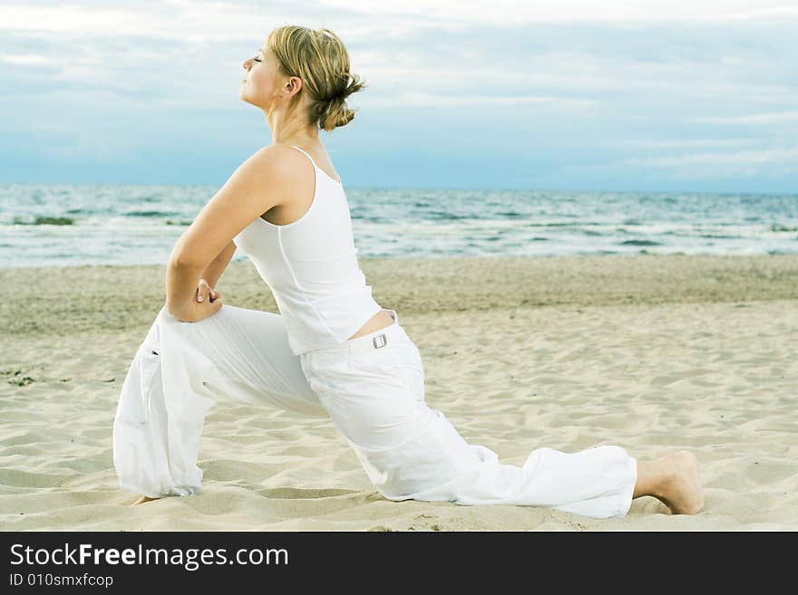 Young cute girl training on the beach. Young cute girl training on the beach.