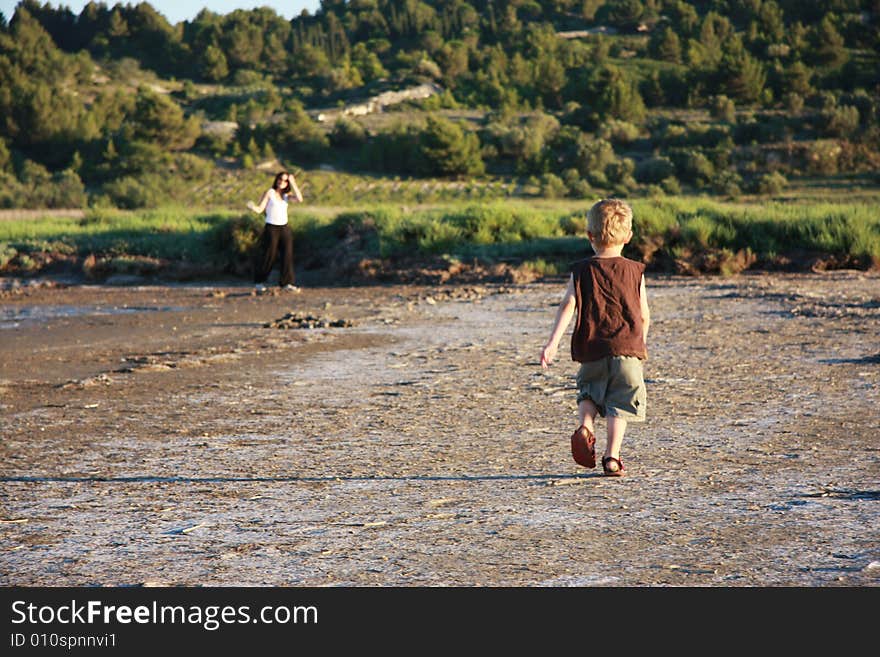 Child running towards his mother in
vineyard country,in the mediterranean. Child running towards his mother in
vineyard country,in the mediterranean.