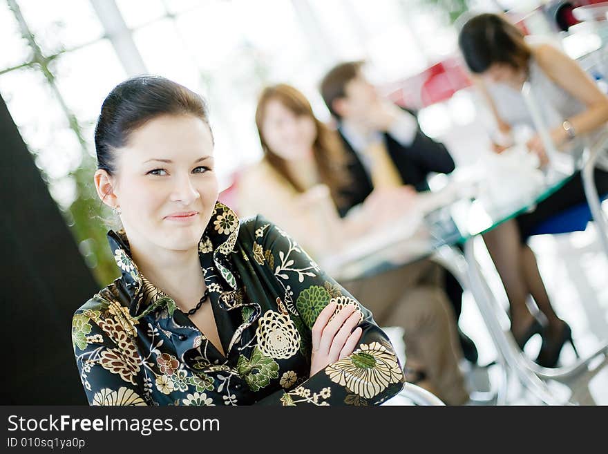 A smiling young woman with her friends at the background. A smiling young woman with her friends at the background