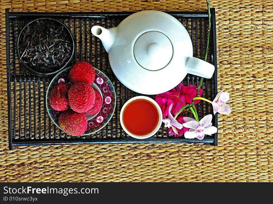 Asian pottery tea set with chinese tea and litchees