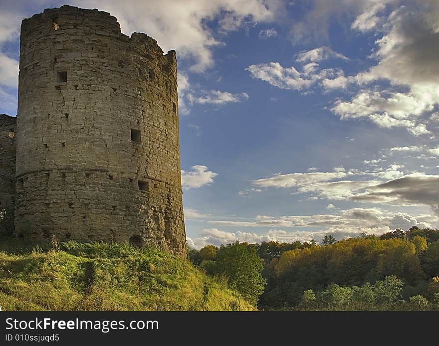 Medieval castle and green trees under blue sky with clouds. Medieval castle and green trees under blue sky with clouds