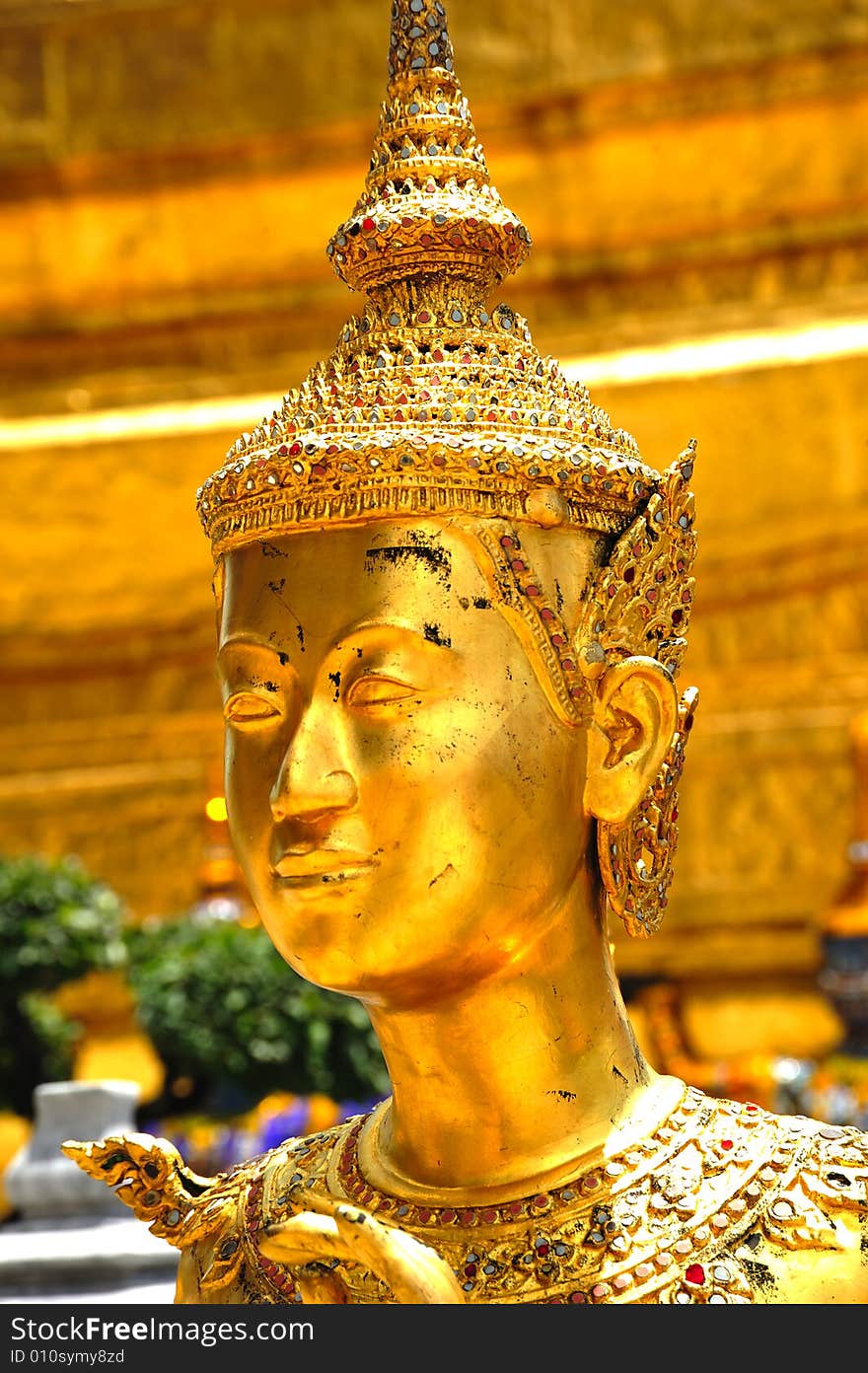 Thailand Bangkok; the wat Phra Kaew shelter the most sacred image of Thailand the Emerald Buddha. The temple is situated in the northeast corner of the Grand Palace. Decorated walls and a golden kannari. Thailand Bangkok; the wat Phra Kaew shelter the most sacred image of Thailand the Emerald Buddha. The temple is situated in the northeast corner of the Grand Palace. Decorated walls and a golden kannari