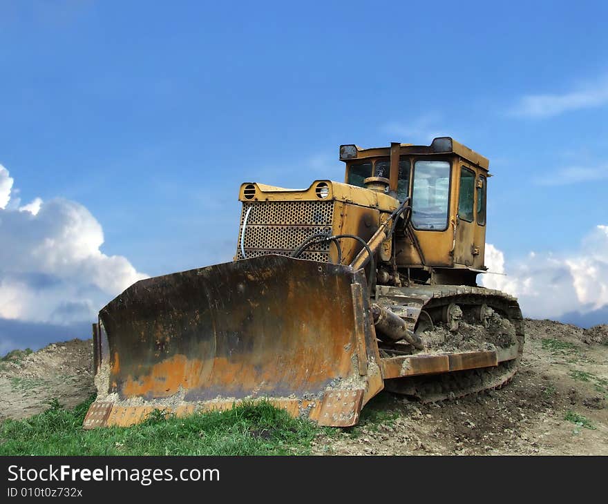 Old and rusty bulldozer stands on barren terrain