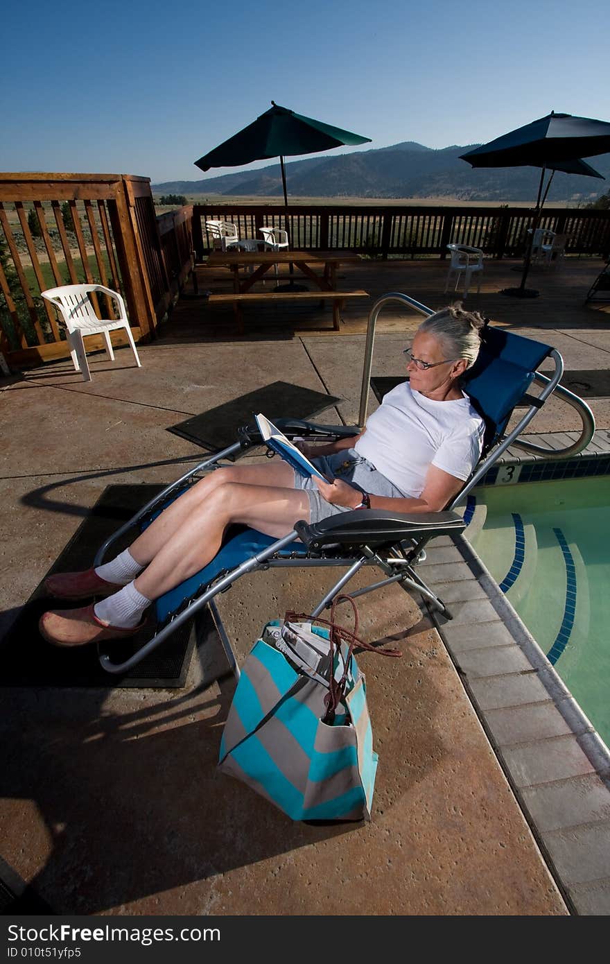 Senior woman sitting by pool