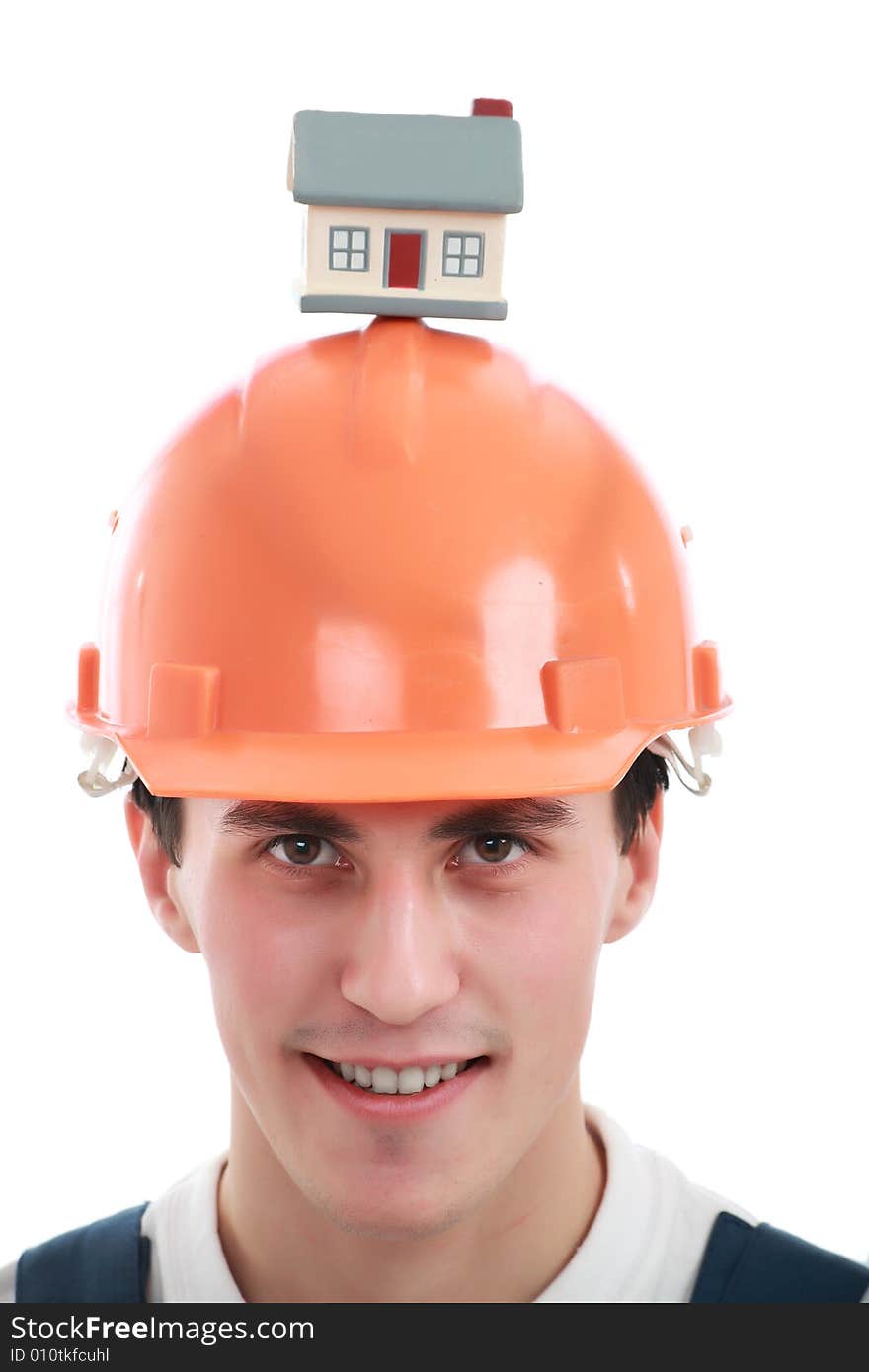 Muscular young man in a builder uniform with house model. Muscular young man in a builder uniform with house model.