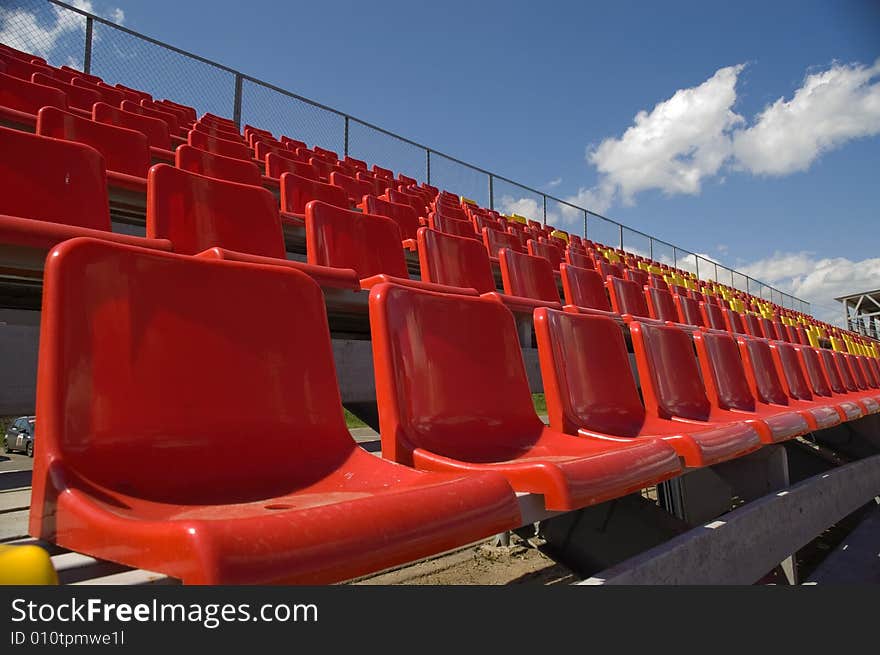 Red seats on a background of the sky with clouds. Red seats on a background of the sky with clouds.