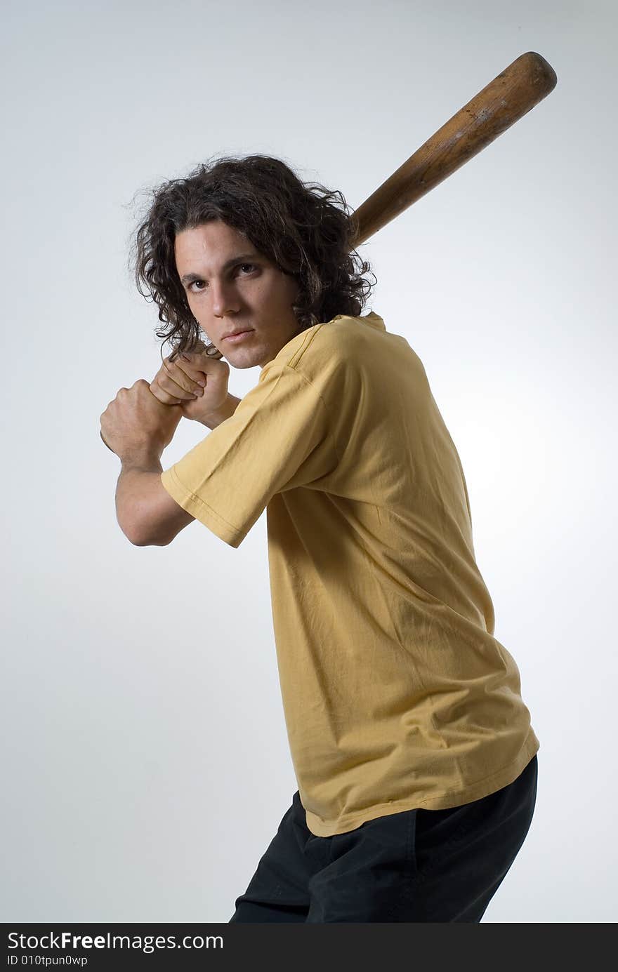 Man with an angry expression holds a baseball bat. Vertically framed photograph. Man with an angry expression holds a baseball bat. Vertically framed photograph