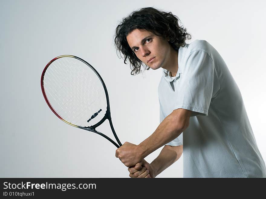 Man with a serious look on his face holds a tennis racket. Horizontally framed photograph. Man with a serious look on his face holds a tennis racket. Horizontally framed photograph