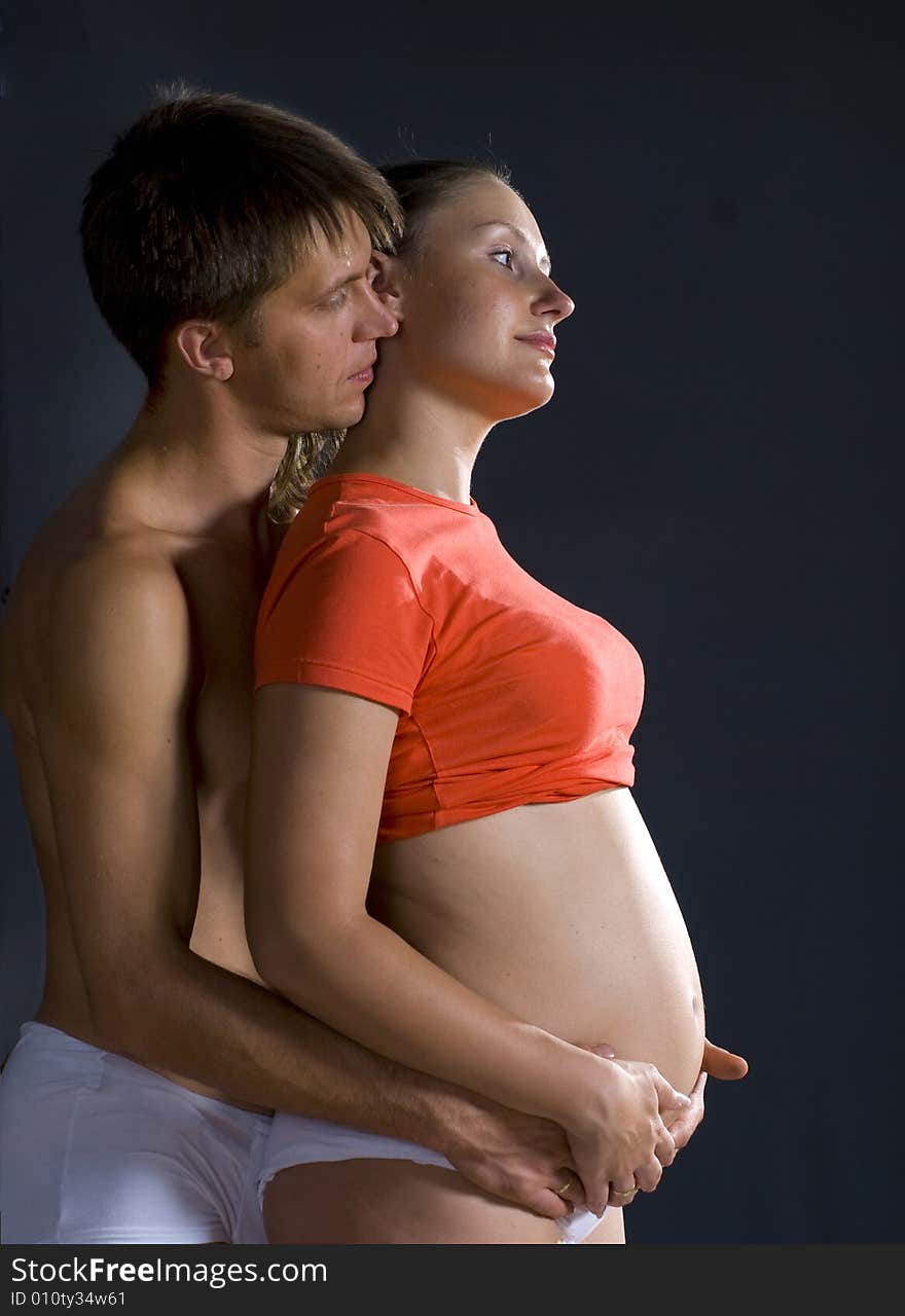 The man and woman with child standing against black background. The man and woman with child standing against black background